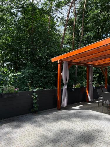 a pavilion with a table and a white umbrella at Domek na Morenowym Wzgórzu, nad jeziorem in Mierzyn