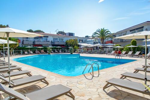 a large swimming pool with chairs and umbrellas at Best Western Plus La Marina in Saint-Raphaël