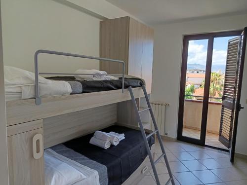 a room with two bunk beds with a balcony at Roby's House in Capo dʼOrlando