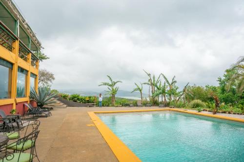a swimming pool in front of a building at Lake Arenal Hotel & Brewery in Tilarán