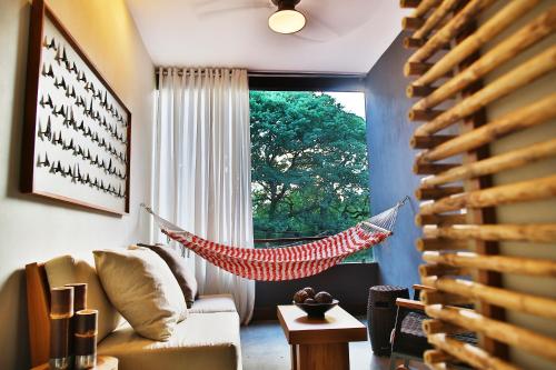 a living room with a hammock in front of a window at El Mangroove Papagayo, Autograph Collection in Papagayo, Guanacaste