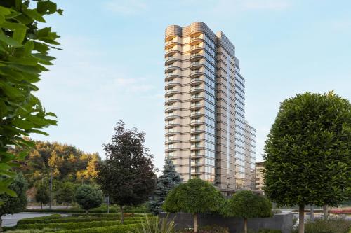 a tall apartment building in a park with trees at Marriott Executive Apartments Istanbul Investvadi in Istanbul