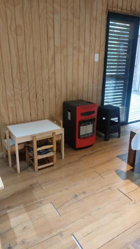 a room with a table and a tv in it at Cabaña Bosque Tumán 