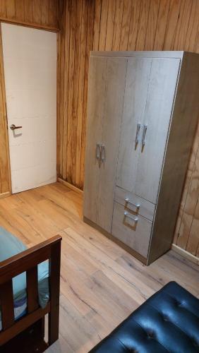 a large metal cabinet in a room with a door at Cabaña Bosque Tumán 