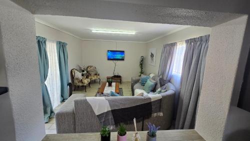 a living room with a couch and a tv at Cosy haven in Harrismith