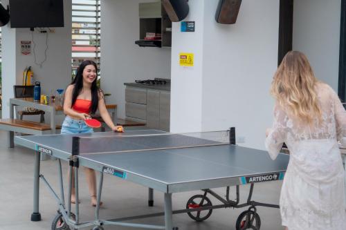 two women playing ping pong on a ping pong table at Hostel Laguna Salá By FSL in Ríohacha