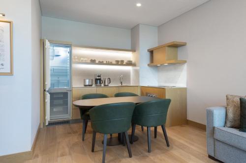 a kitchen with a table and some green chairs at Marriott Executive Apartments Istanbul Investvadi in Istanbul