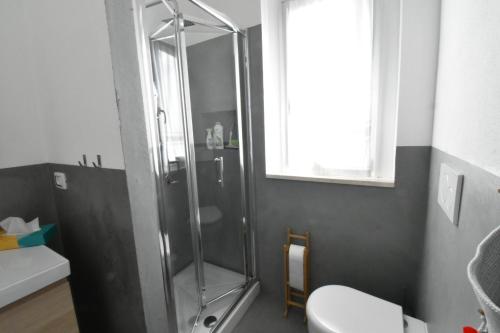 a bathroom with a shower and a toilet and a sink at Villa Virginia in Sarroch