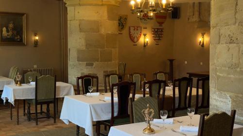 a dining room with tables and chairs with white table cloth at L'Hostellerie du Château de Bricquebec in Bricquebec