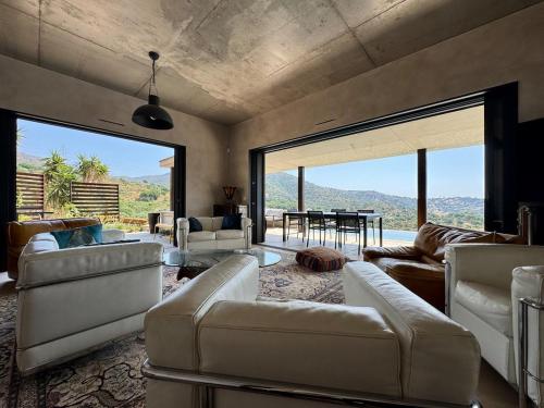 a living room with couches and a table with a view at Villa la Caladine in a quiet location in Bormes-les-Mimosas