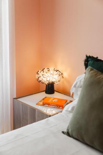 a nightstand with a lamp and a book on a bed at Tenuta Borgo Santa Cecilia in Gubbio