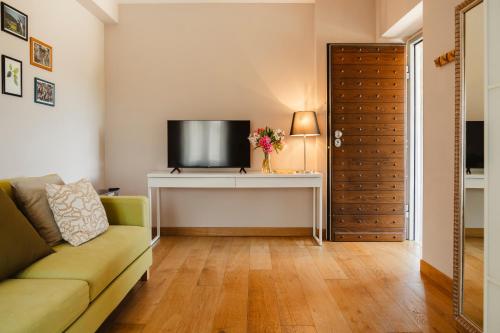 a living room with a couch and a television at Tenuta Borgo Santa Cecilia in Gubbio