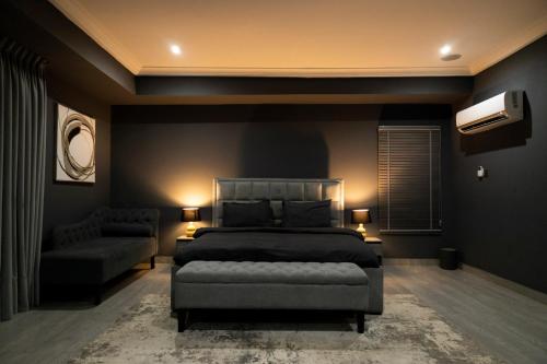 a bedroom with a bed and a couch at Self made Estates in Accra