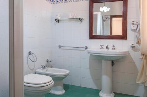 a bathroom with a toilet and a sink and a mirror at Sant'Antonio in Volterra