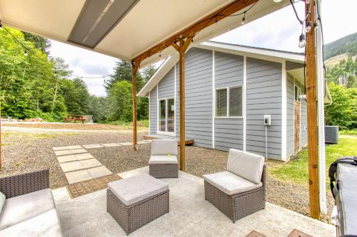 an outdoor patio with chairs and a house at Nehalem Coastal Oasis - Secluded Coastal Home with Hot Tub on 14 Acres in Nehalem