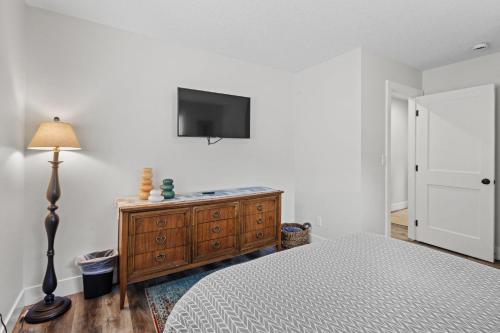 a bedroom with a bed and a tv on a wall at Nehalem Coastal Oasis - Secluded Coastal Home with Hot Tub on 14 Acres in Nehalem
