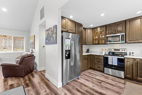 a kitchen with wooden cabinets and a stainless steel refrigerator at Nehalem Coastal Oasis - Secluded Coastal Home with Hot Tub on 14 Acres in Nehalem