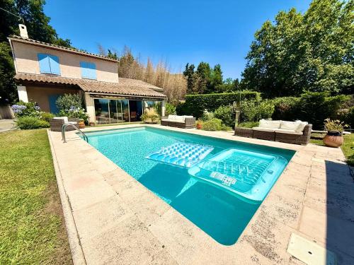 une piscine devant une maison dans l'établissement Un appartement 2 pièces dans une villa avec piscine et parking, à Vence