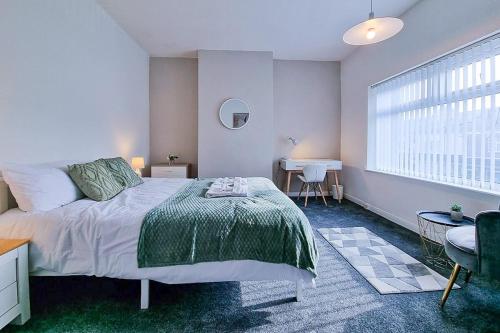 ein Schlafzimmer mit einem Bett und einem Tisch und einem Fenster in der Unterkunft Modern Comforts in Cleethorpes in Cleethorpes