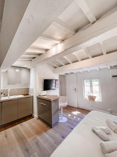 Cette chambre comprend une cuisine avec un évier et un bureau. dans l'établissement Suite des Tisserands, à Saint-Tropez