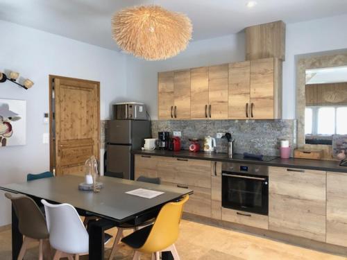 d'une cuisine avec une table et des chaises jaunes. dans l'établissement La Chapelle de Monet - Logis Jasmin, à Bois-Jérôme-Saint-Ouen