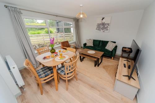 a living room with a table and a green couch at The Hebridean - Rooms & Apartments in Broadford