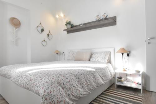 a white bedroom with a bed with a white comforter at Villa Virginia in Sarroch