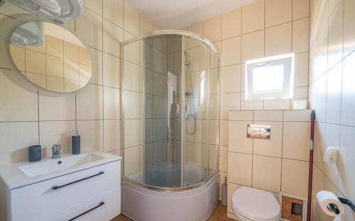 a bathroom with a shower and a toilet and a sink at Domki u Bogdana in Dąbki