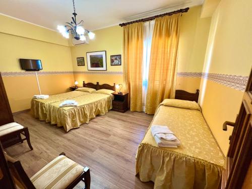 a hotel room with two beds and a tv at Ai Tre Parchi Bed And Bike in Randazzo