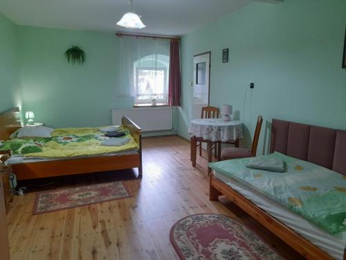 a living room with two beds and a table at Lipowy Dwór in Laskówka