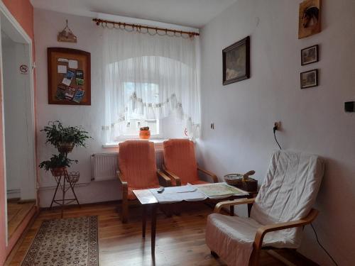 a living room with a table and chairs and a window at Lipowy Dwór in Laskówka