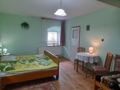 a bedroom with a bed and a table with a lamp at Lipowy Dwór in Laskówka