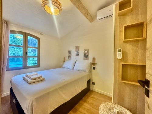 une chambre avec un lit avec des draps blancs et une fenêtre dans l'établissement La Casettina, à Saint-Tropez
