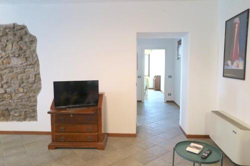 a living room with a tv on a dresser at Residenza La Rocca 1227 - Borgo Castello di Serravalle in Castello di Serravalle
