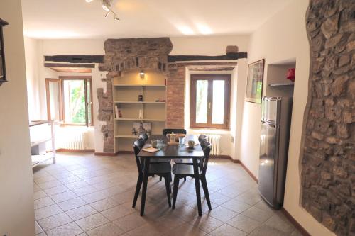 a dining room with a table and a refrigerator at Residenza La Rocca 1227 - Borgo Castello di Serravalle in Castello di Serravalle