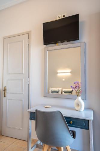 a blue desk with a chair and a mirror at Filoxenia Apartments in Mytilini