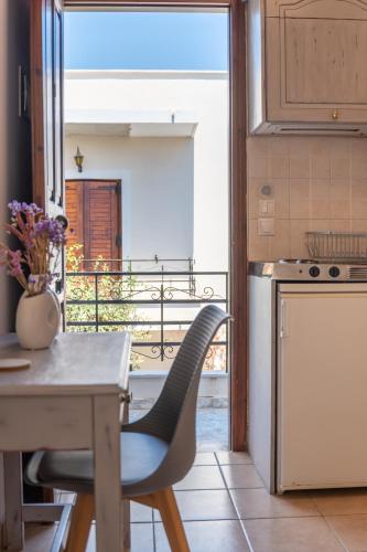 a kitchen with a table and a view of a balcony at Filoxenia Apartments in Mytilini