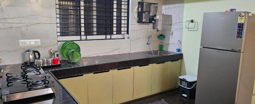 a kitchen with a stainless steel refrigerator and a sink at Home Inn in Mysore