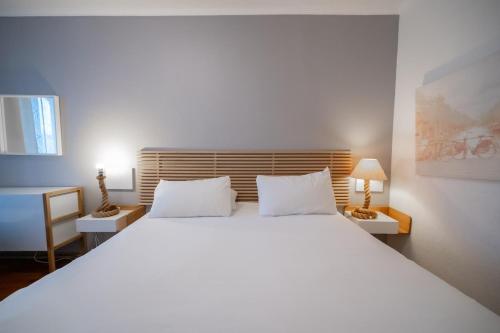 Postel nebo postele na pokoji v ubytování Hotel Les Arcades
