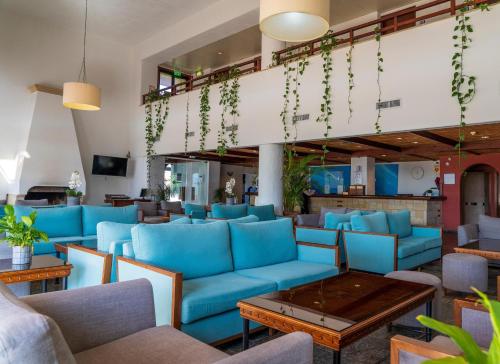 a lobby with blue couches and tables at Paphos Gardens Holiday Resort in Paphos