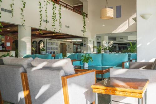 a restaurant with blue chairs and tables at Paphos Gardens Holiday Resort in Paphos