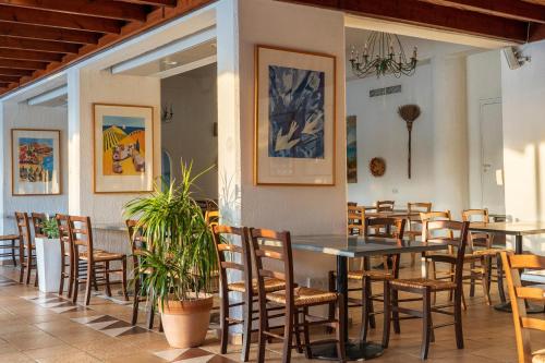 a restaurant with tables and chairs in a room at Paphos Gardens Holiday Resort in Paphos