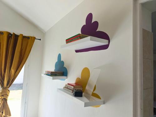a room with shelves on the wall with books at La Maison du Sapin 