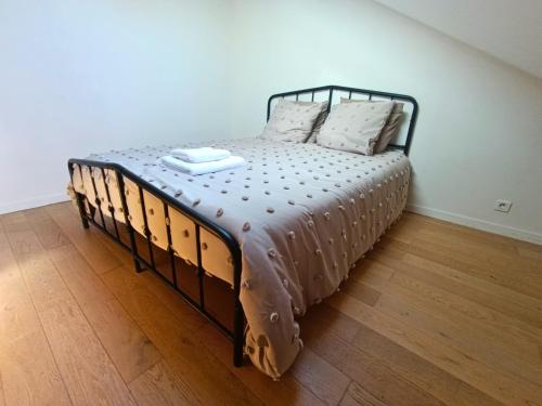 a bed in a room with a wooden floor at La Maison du Sapin 