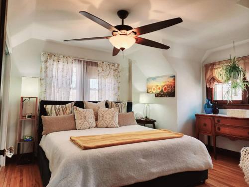 a bedroom with a large bed with a ceiling fan at Downtown Boho Home wOffice Yoga StudioKing Bed in La Crosse