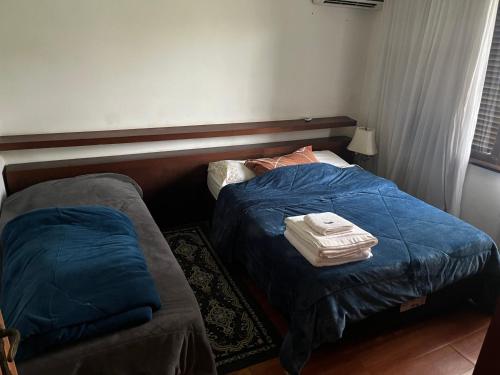 a bedroom with two beds with blue comforter at Suíte do Morro in Pomerode