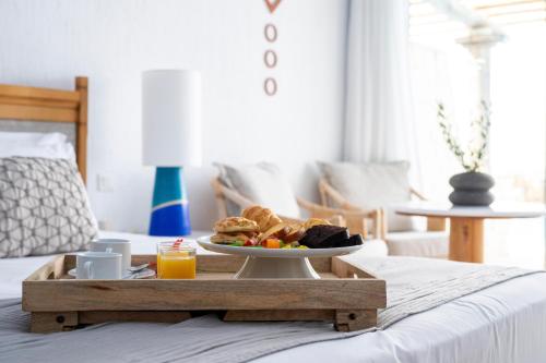 a tray with a plate of food on a bed at Leptos Panorama Hotel in Kalamaki Chanion