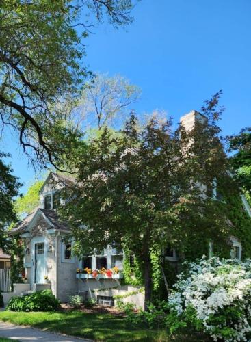 a white house with flowers in a yard at Downtown Boho Home wOffice Yoga StudioKing Bed in La Crosse