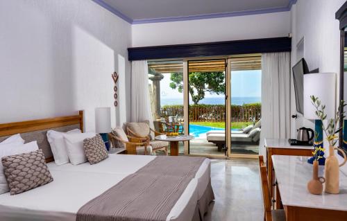 a bedroom with a bed and a living room at Leptos Panorama Hotel in Kalamaki Chanion