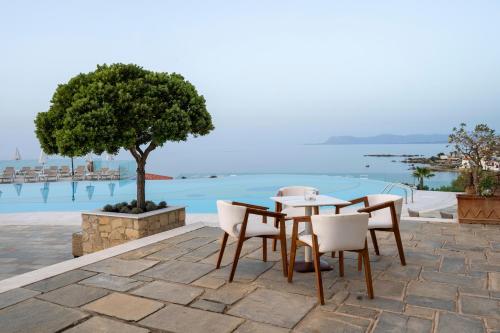 a table and chairs with a view of the water at Leptos Panorama Hotel in Kalamaki Chanion